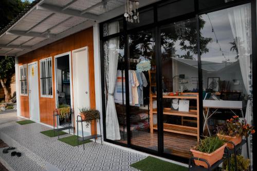 a store front with large glass windows and plants at Olive Hostel Roxas City in Roxas City