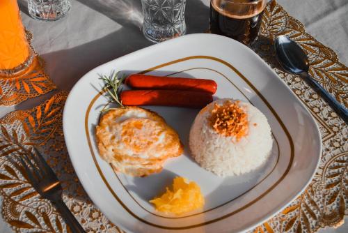 a plate of food with rice and carrots on a table at Olive Hostel Roxas City in Roxas City
