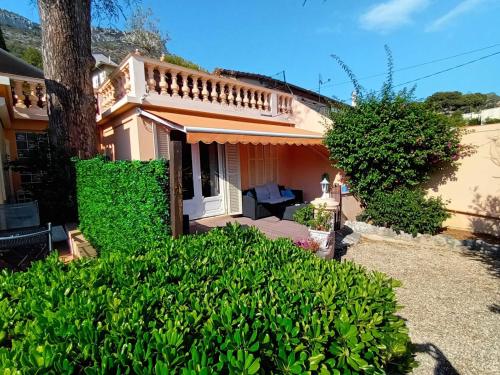 a small house with a porch and bushes at Appartement charmant et calme aux portes de Monaco in Cap d'Ail