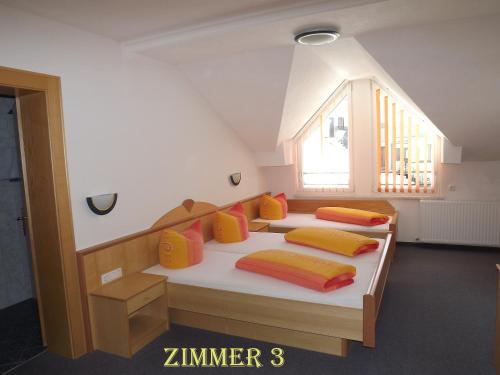 two beds with colorful pillows on them in a room at Apart Birgit in Kappl