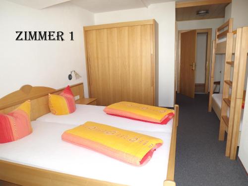 a room with two beds with yellow and red pillows at Apart Birgit in Kappl