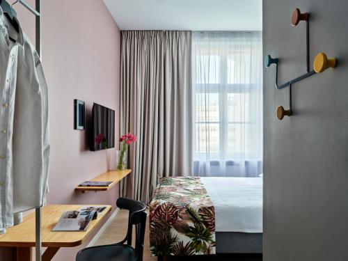 Pokój hotelowy z łóżkiem, biurkiem i oknem w obiekcie HOLA GDYNIA w mieście Gdynia