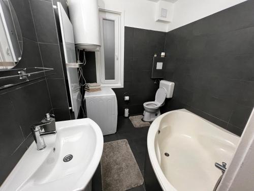 La salle de bains est pourvue d'un lavabo, d'une baignoire et de toilettes. dans l'établissement Dave Apartman 2, à Szeged