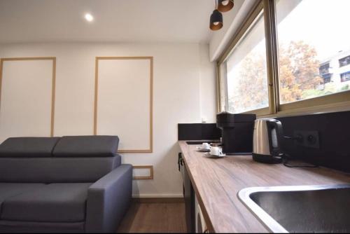 a kitchen with a couch and a sink in a room at Prado Marseille 8eme studio in Marseille