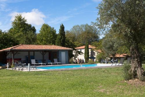 une maison avec une piscine dans une cour dans l'établissement LA CAVERIE DE PEYROUX A ORTHEVIELLE (40300), à Orthevielle