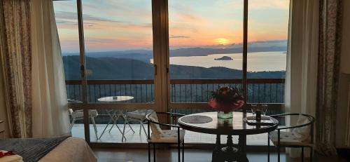 a room with a table and a balcony with a view at Belvedere del Lago in Montefiascone
