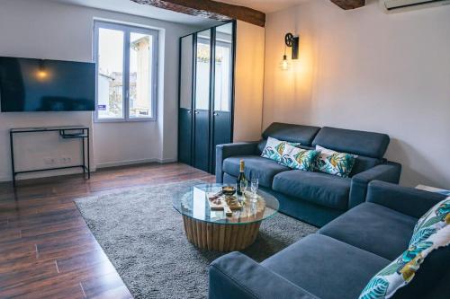 a living room with a couch and a table at Appartement climatisé avec garage au cœur du centre ancien in Sainte-Maxime