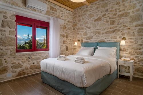 a bedroom with a large bed with a red window at Physis Country House 2 near Matala beach & Faistos in Kousés