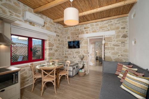 a kitchen and living room with a table and chairs at Physis Country House 2 near Matala beach & Faistos in Kousés