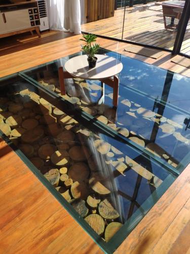 a glass floor with a table and rocks in a room at Cabana Mundo Novo in Gonçalves