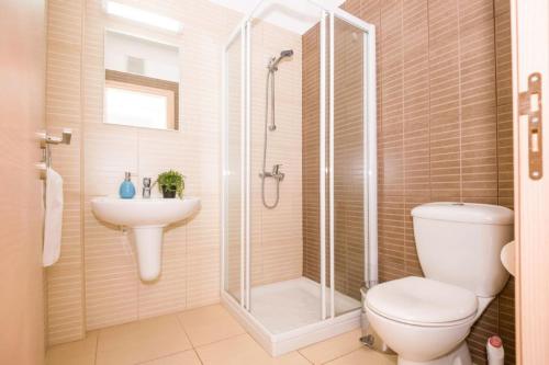 a bathroom with a shower and a toilet and a sink at LAILA - Coralli Beachfront Apartment in Protaras