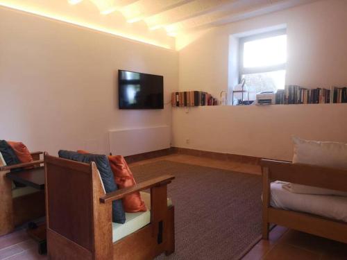 - un salon avec un canapé et une télévision murale dans l'établissement Romantic Stay in Grand Setting, à Alella