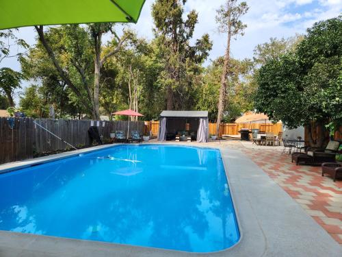 una piscina en un patio con sombrilla en Garden Clara en Yuba City