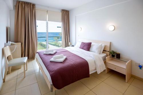 een hotelkamer met een bed en een groot raam bij GABRIELA - Beachfront Apartment in Protaras