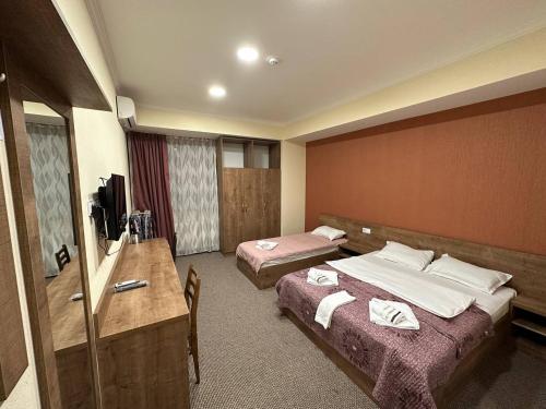 Habitación de hotel con 2 camas y escritorio en 5 Rooms near 300 Aragveli metro station en Tiflis