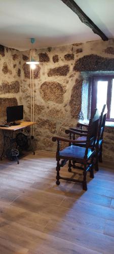 a room with a table and chairs in a stone wall at Casa do Carregal in Braga