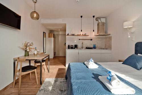 a bedroom with a bed and a table and a kitchen at Aparthotel Anchoria BlueApart in Mechelinki