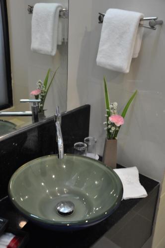 a bathroom with a green sink and a mirror at The Gallery At Koh Chang in Ko Chang