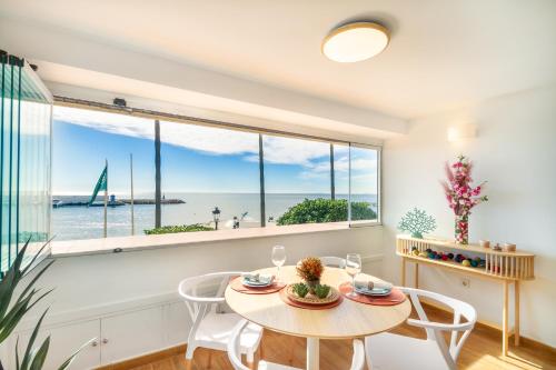 une salle à manger avec une table, des chaises et une grande fenêtre dans l'établissement MARBELLA BANUS SUITES - Marbella Beach Front Suite Apartment, à Marbella
