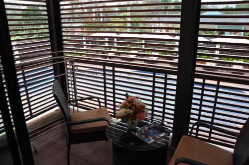 a table and chairs in front of a window with blinds at The Gallery At Koh Chang in Ko Chang