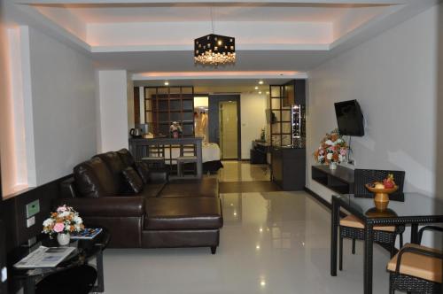 a living room with a leather couch and a dining room at The Gallery At Koh Chang in Ko Chang