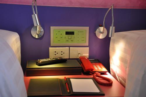 a room with a bed with a desk with a phone at The Gallery At Koh Chang in Ko Chang