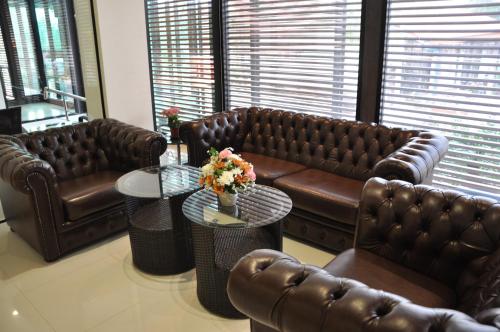 a living room with brown leather couches and a table at The Gallery At Koh Chang in Ko Chang