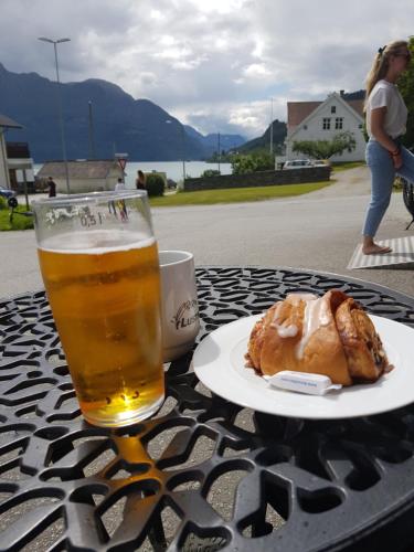 um copo de cerveja e um prato de comida numa mesa em Molden 2-fjellutsikt og jacuzzi tilgang. em Luster