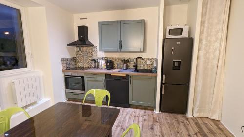 Il comprend une cuisine équipée d'un réfrigérateur, d'une table et de chaises. dans l'établissement Le Puy de Côme, à Saint-Diéry