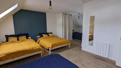 sypialnia z 2 łóżkami i niebieską ścianą w obiekcie Le Puy de Côme w mieście Saint-Diéry