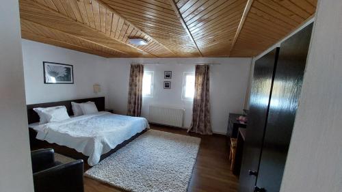 a bedroom with a bed and a wooden ceiling at Casa Victoria in Moieciu de Sus