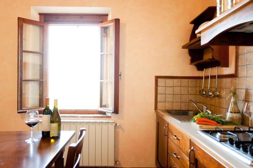a kitchen with a window and a table with wine glasses at Fattoria Fibbiano in Terricciola