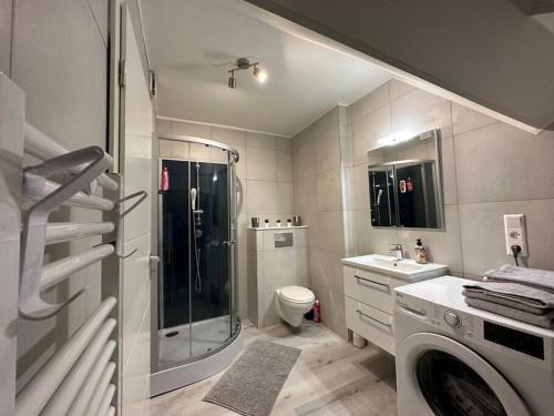 a bathroom with a shower and a washing machine at Amazing Hyper Central Flat- Esch in Esch-sur-Alzette