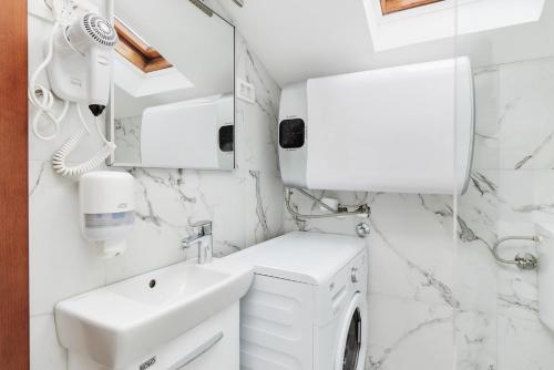 a bathroom with a sink and a washing machine at Apartments Rozer in Kotor