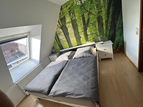 um quarto com uma cama e um mural de árvores em Mühlenparadies Hameln em Hessisch Oldendorf