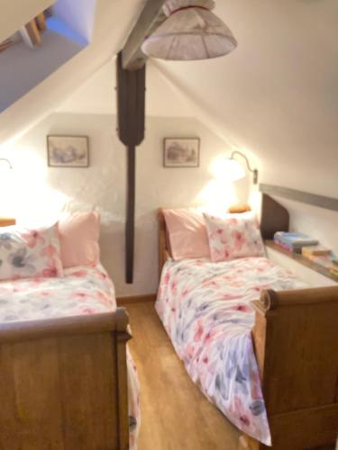 1 dormitorio con 2 camas en un ático en la Bodangeoise gîte rural, en Fauvillers