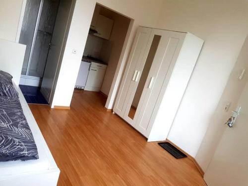 Habitación vacía con puerta y suelo de madera en Helles Apartment, en Neutraubling
