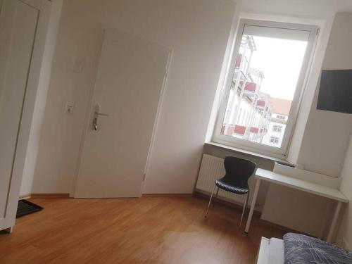 an empty room with a chair and a window at Helles Apartment in Neutraubling