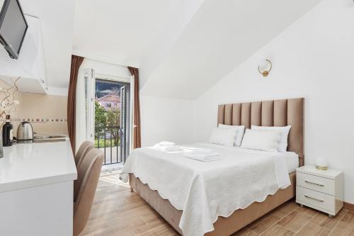 Un dormitorio con una cama grande y una ventana en Apartments Rozer, en Kotor