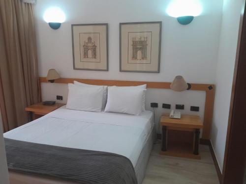 Bonaparte Hotel Residence - Suite 803 في برازيليا: غرفة نوم بسرير ابيض وموقف ليلتين
