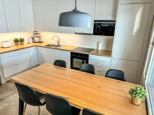 cocina con mesa de madera y sillas en Vuokatin kultaranta en Sotkamo