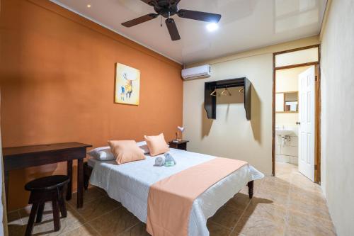 1 dormitorio con 1 cama, escritorio y ventilador de techo en El Cocobolo Food&Rest Room 5 Bed and Breakfast WiFi AC Pkg gratis, en Liberia