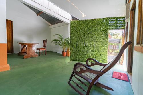 a room with a bench and a green wall at Hotel El Cocobolo Food&Rest Room 5 B&B WiFi AC Pkg Free Swimmingpool in Liberia