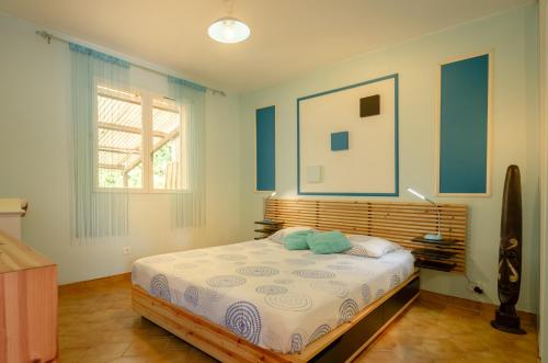 une chambre avec un lit aux murs bleus et une fenêtre dans l'établissement Villa climatisée avec piscine, à Bagnols-en-Forêt