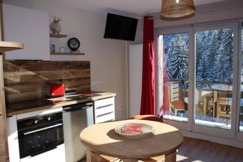 a kitchen with a table and a window and a table at Le Cristal du Mont-Blanc in Saint-Gervais-les-Bains