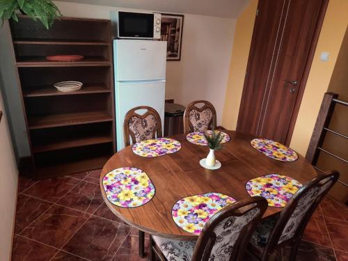 a dining room table with chairs and a refrigerator at V přírodě na okraji Frenštátu pod Radhoštěm in Frenštát pod Radhoštěm