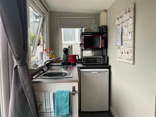 a small kitchen with a sink and a microwave at Bumble’s Barn in Slamannan