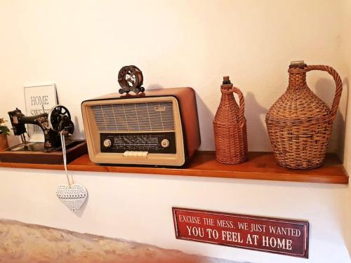 a shelf with a radio and two vases on it at Vintage stone house ELDO in Podaspilje, Omiš in Omiš
