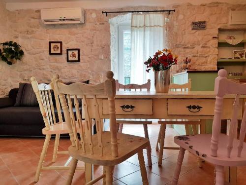 a living room with a wooden table and chairs at Vintage stone house ELDO in Podaspilje, Omiš in Omiš