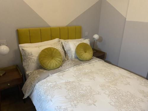 Una cama con dos almohadas verdes encima. en Urban Pod Hotel Liverpool en Liverpool